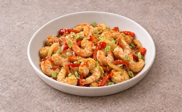 A serving of asian shrimp stir-fry on a plain white dish